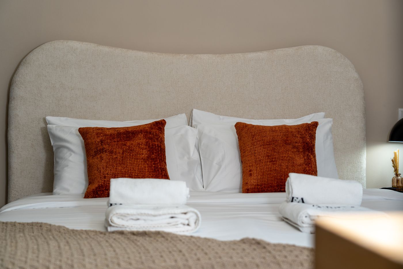 Lit préparé avec linge hôtelier et coussins