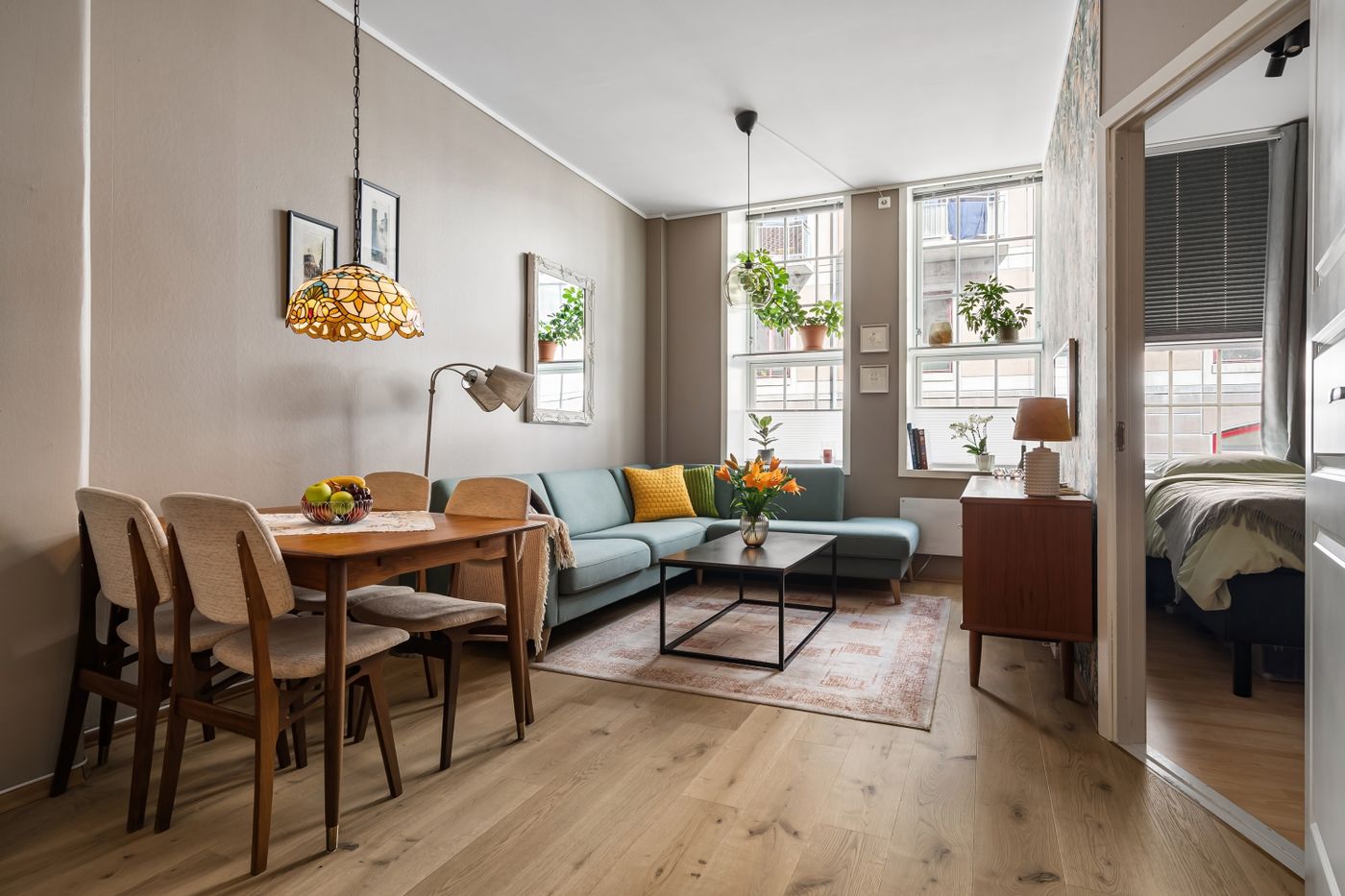 Salon avec coin repas, mobilier en bois et plantes